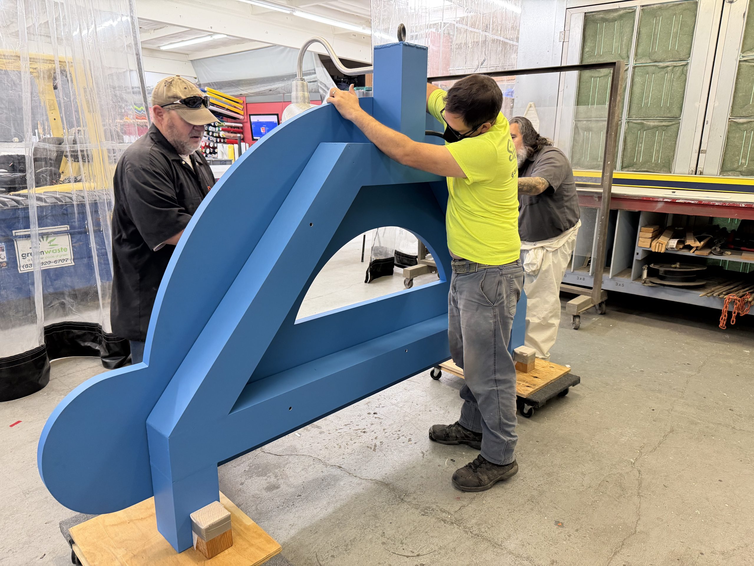 Signworks crew assembling new Sandbar and Grill sandblasted sign onto custom aluminum frame in the shop