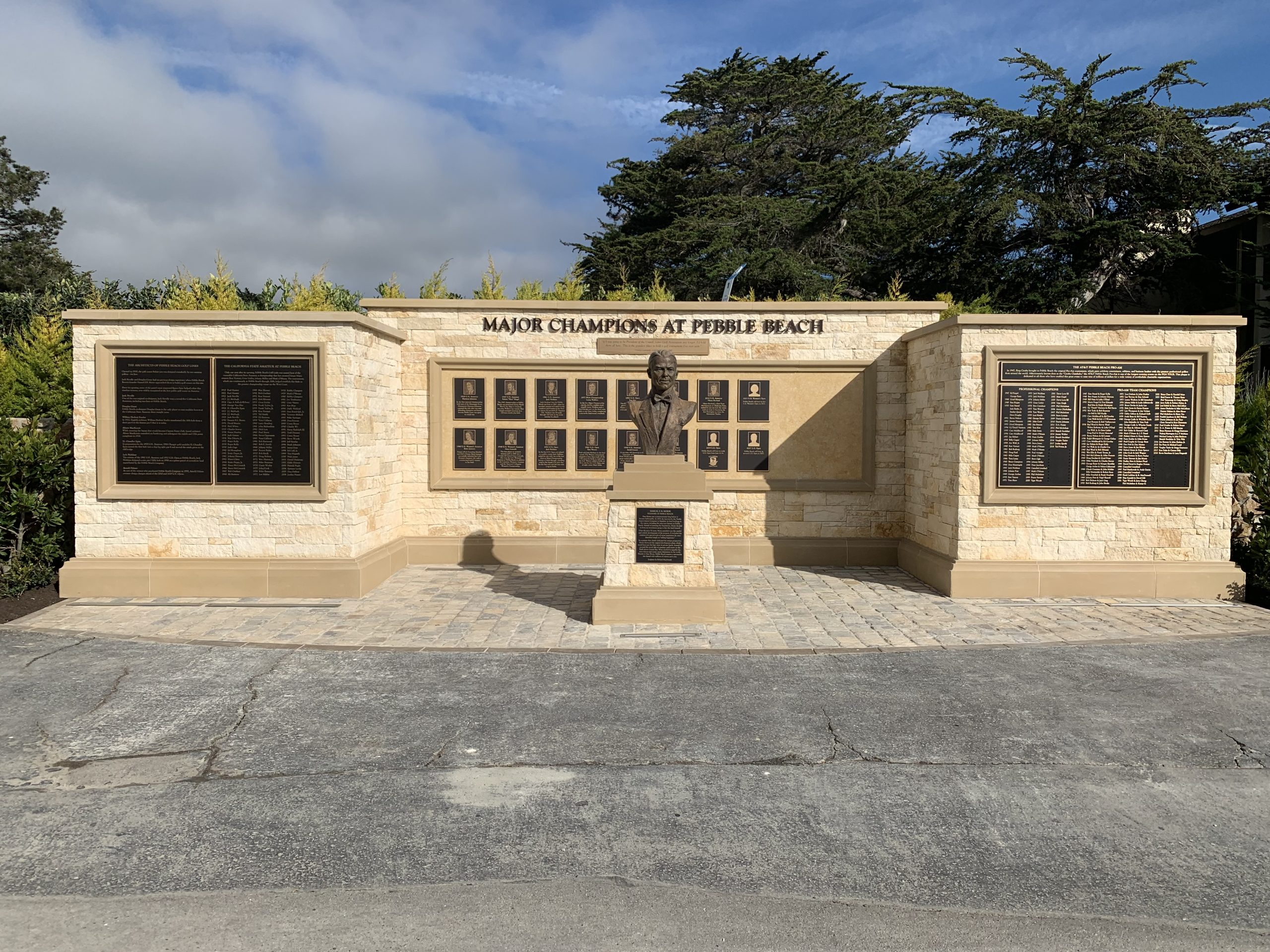Major Champions at Pebble Beach wall featuring cast bronze plaques with photographic portraits, dimensional bronze lettering, and a bronze bust -- installed by Signworks alongside the stonemason team