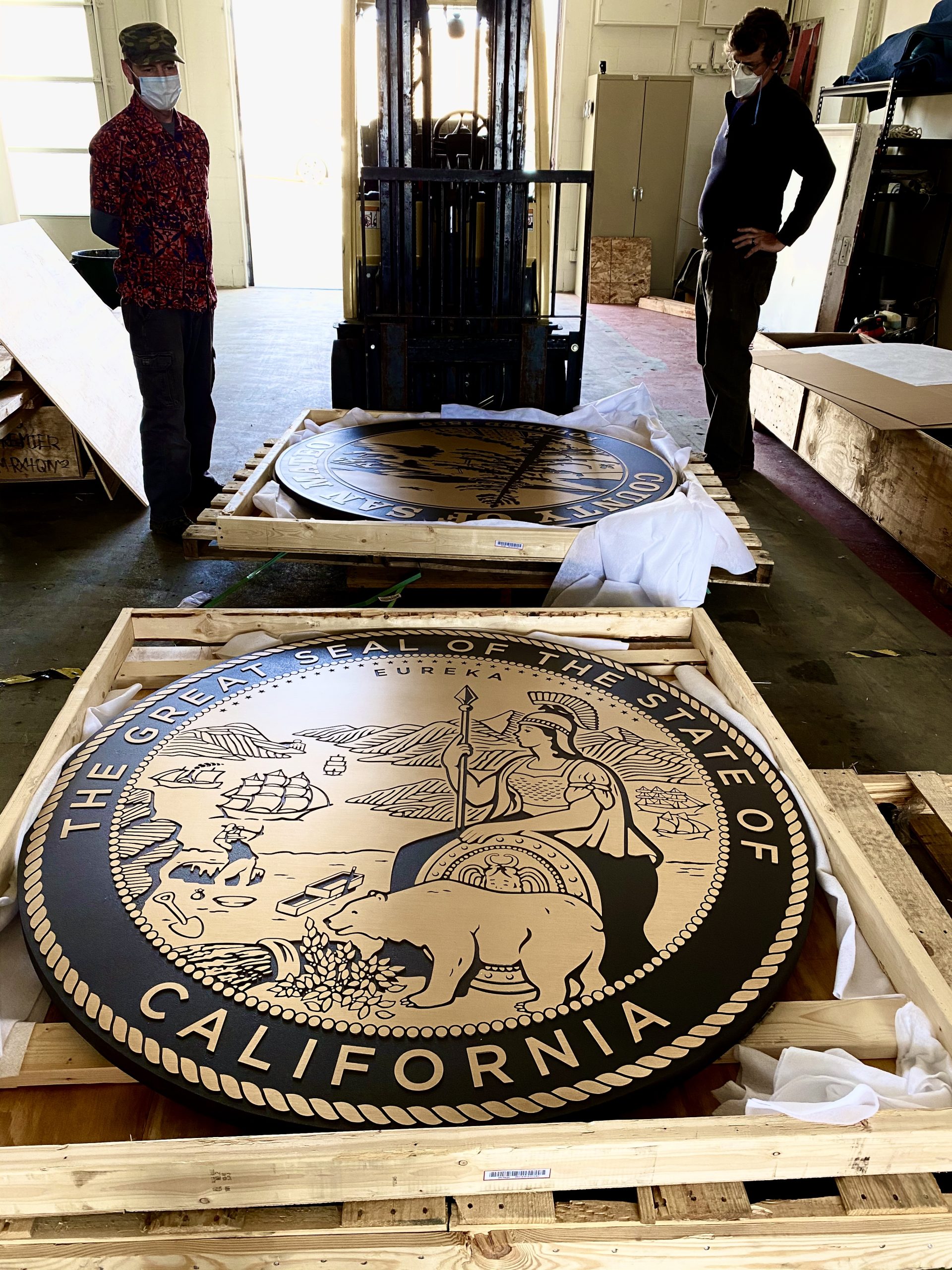 Two massive cast bronze plaques being uncrated at the Signworks shop for installation at the San Mateo County Courthouse
