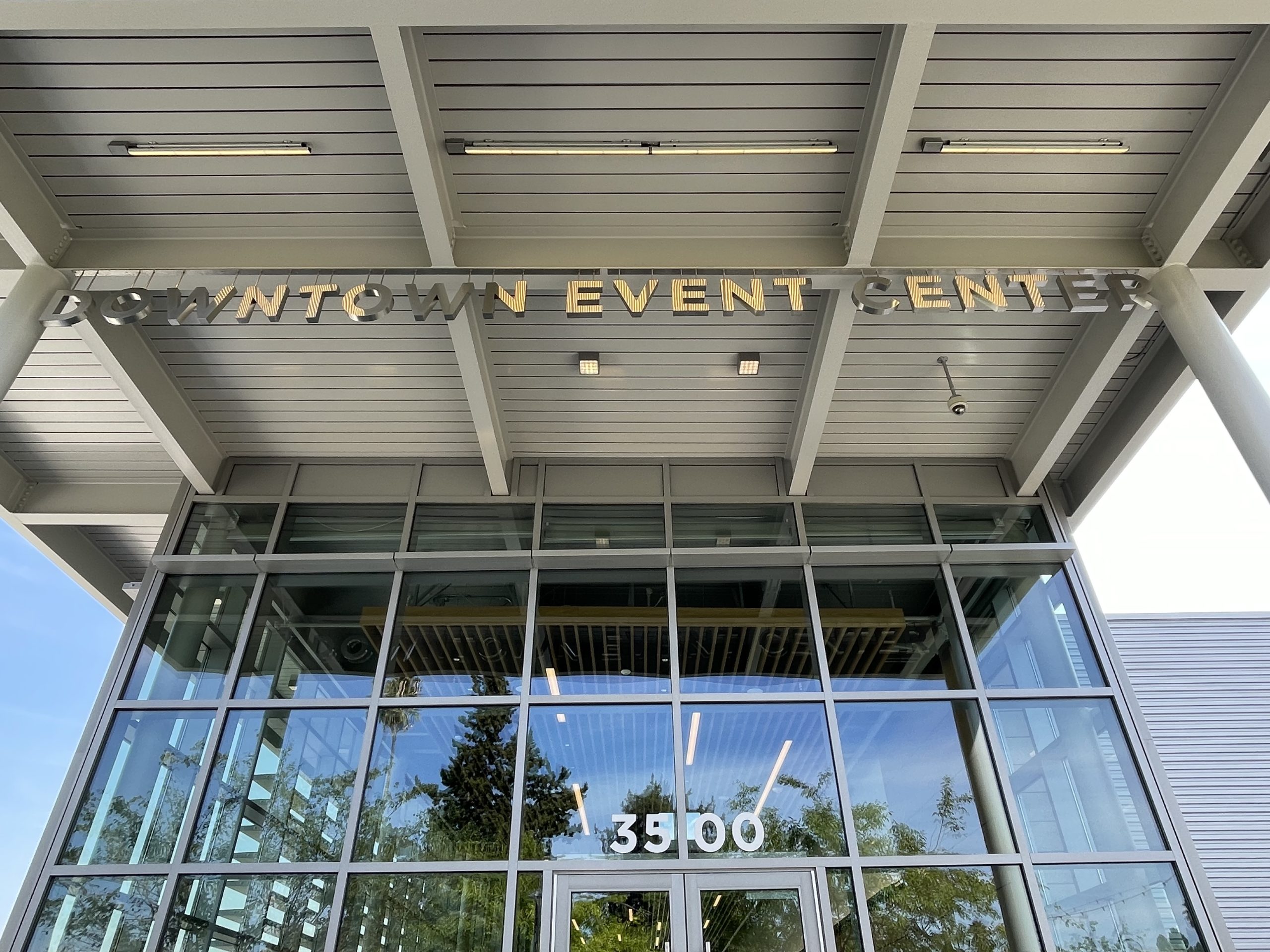 Close-up detail of pin-mounted dimensional letters showing the shadow effect created by concealed pin standoffs on the metal louver facade of the Fremont Downtown Event Center