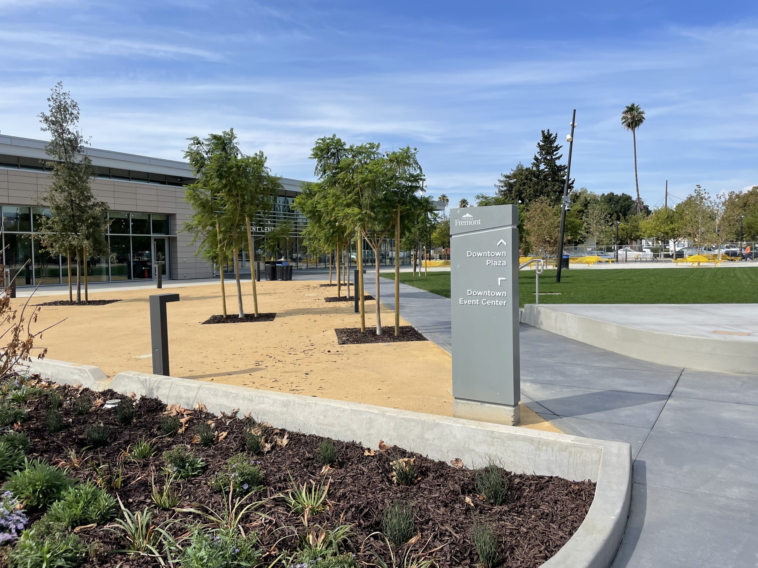 Fremont Downtown Event Center exterior showing the warm terracotta cladding, textured metal panel systems, and transparent glass lobby designed by STUDIOS Architecture