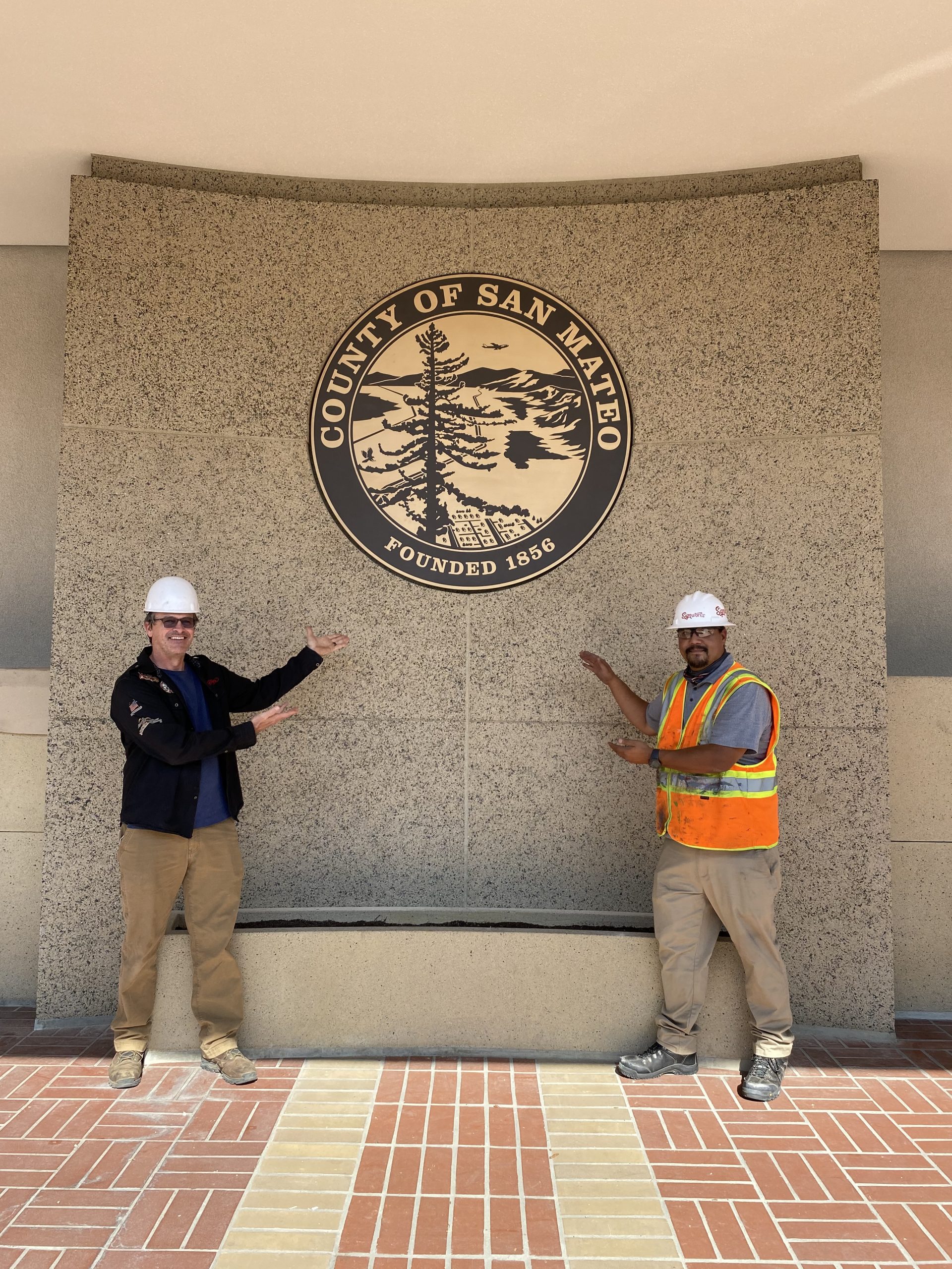 County of San Mateo bronze plaque installed on the courthouse wall with workers shown for scale