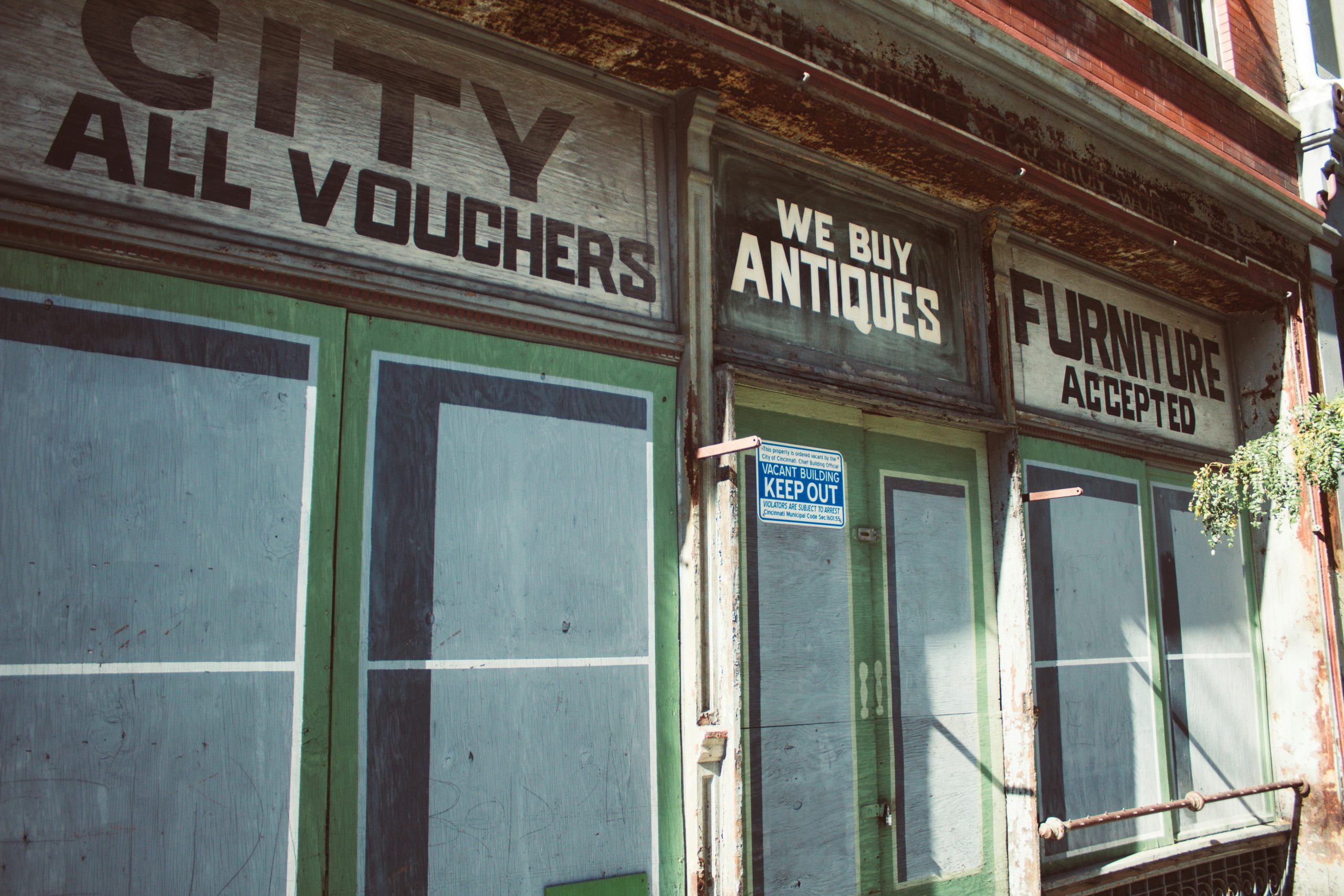 A weathered building with a faded, deteriorating sign that has lost its visual impact