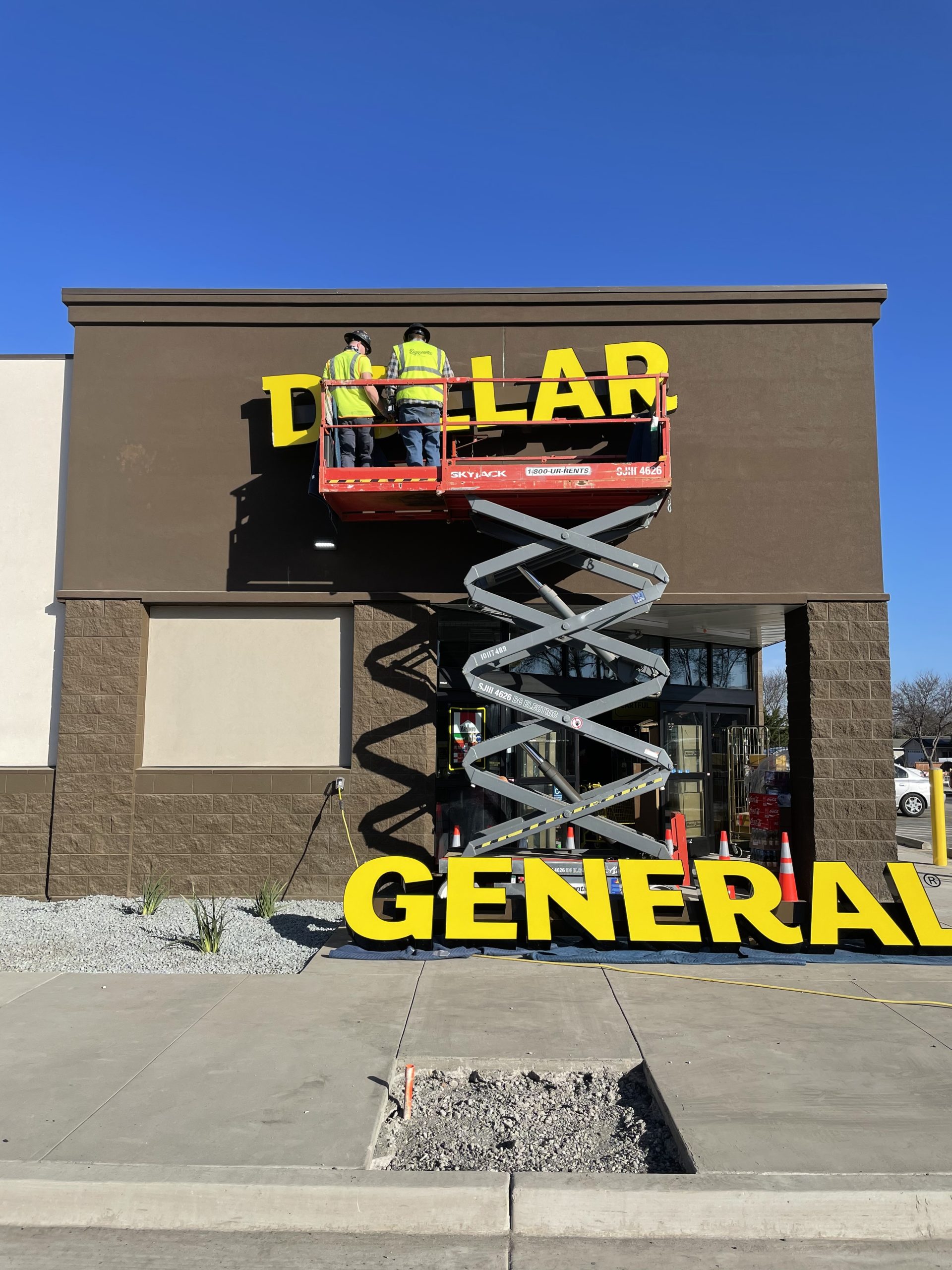Signworks crew installing Dollar General channel letters from a scissor lift in Monterey County