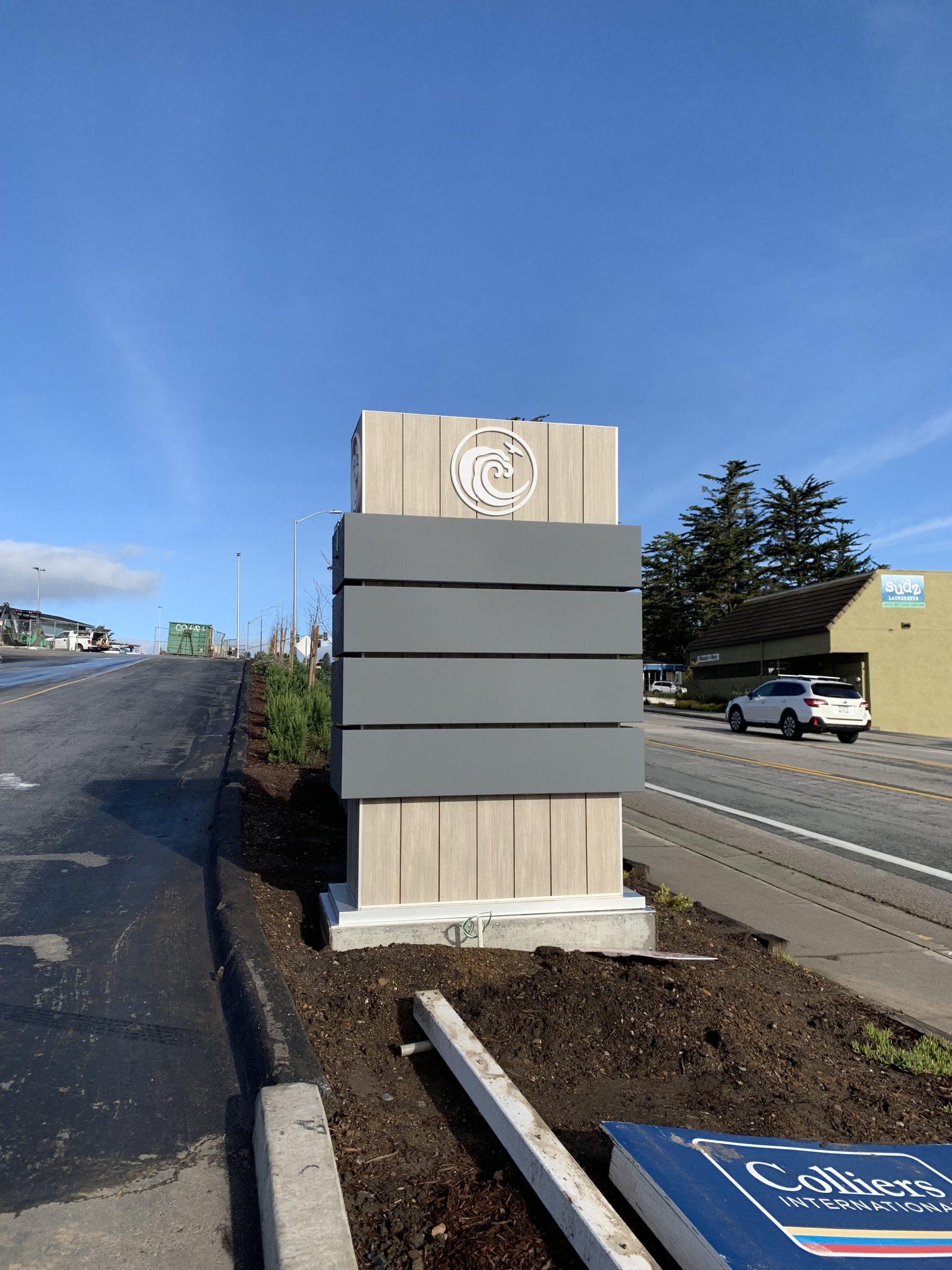 Newly installed Rancho Del Mar monument sign with tenant panel slots along roadside