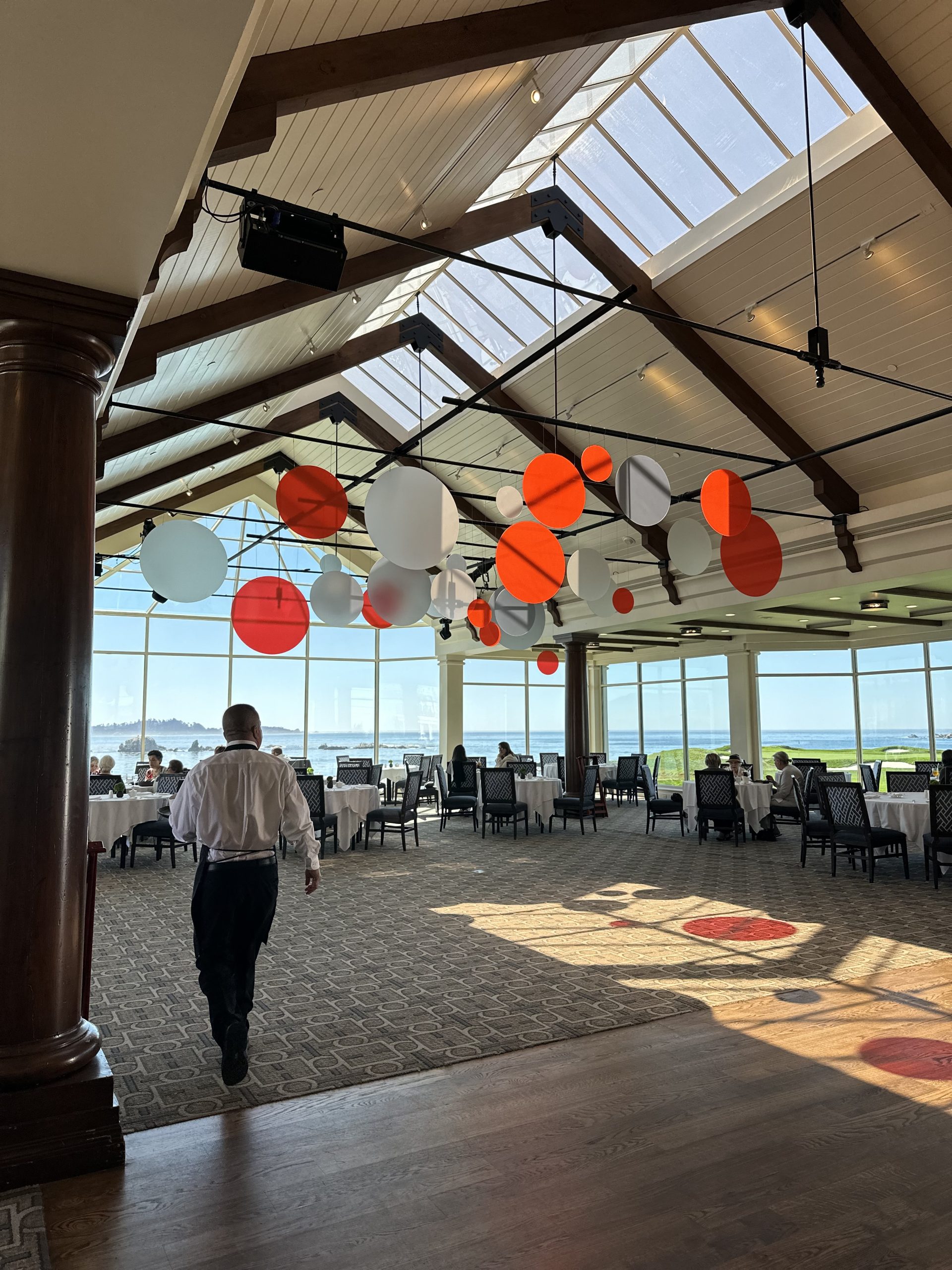 Adobe branded hanging acrylic circle installation suspended from the ceiling of a Monterey event space with natural light