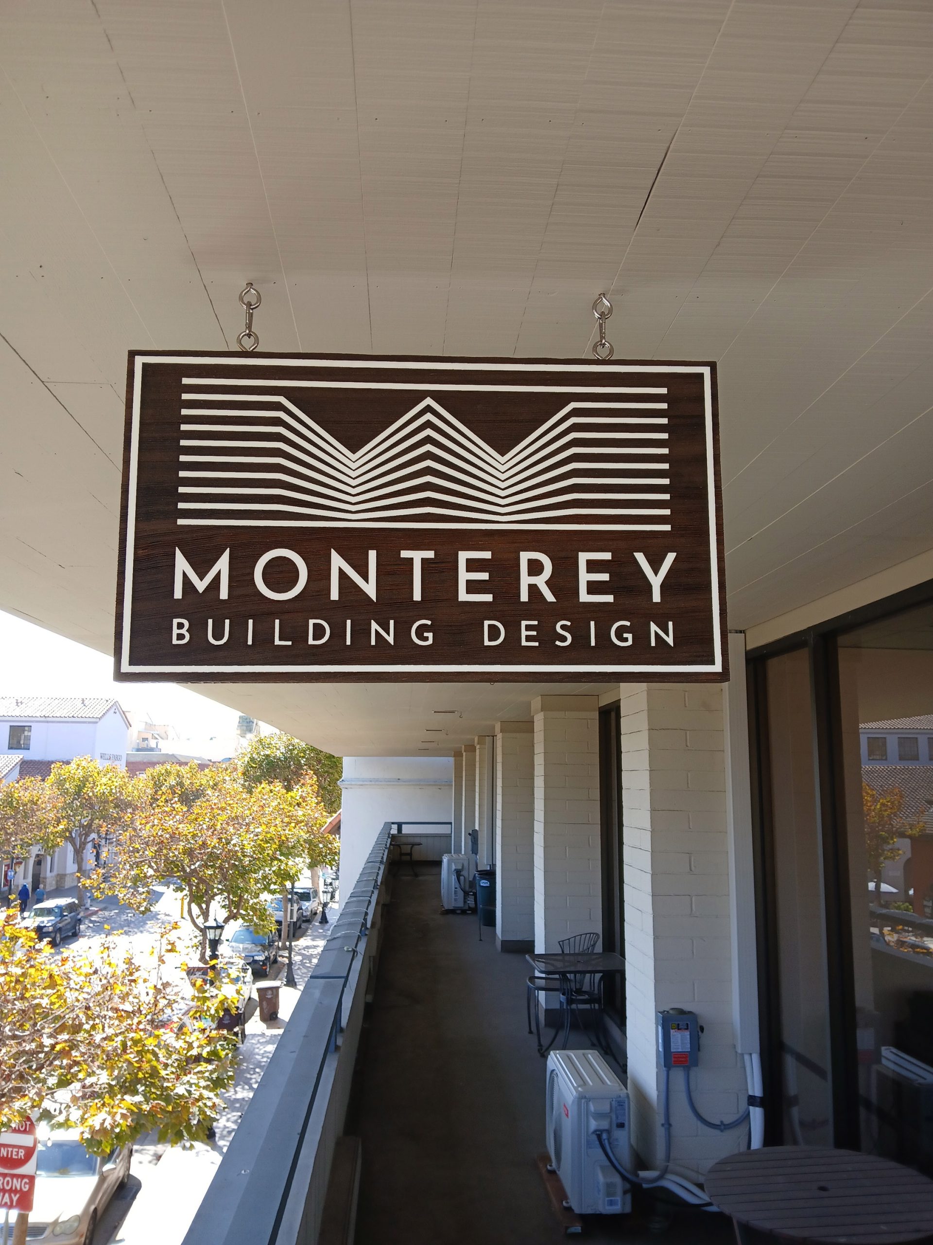 Monterey Building Design hanging sign installed on second-floor walkway